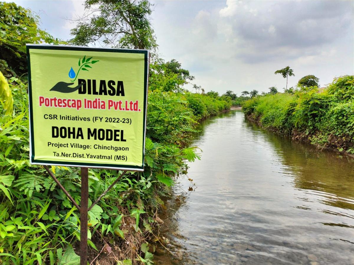 A Dilasa Doha Model site marker beside a stream running full after the monsoon