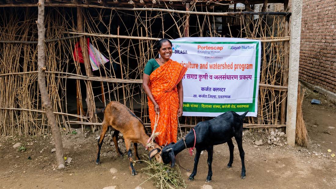 A beneficiary with the goats supplied through her Self-Help Group